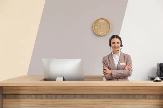 Front Office Worker serving a customer while an AI phone receptionist handles calls