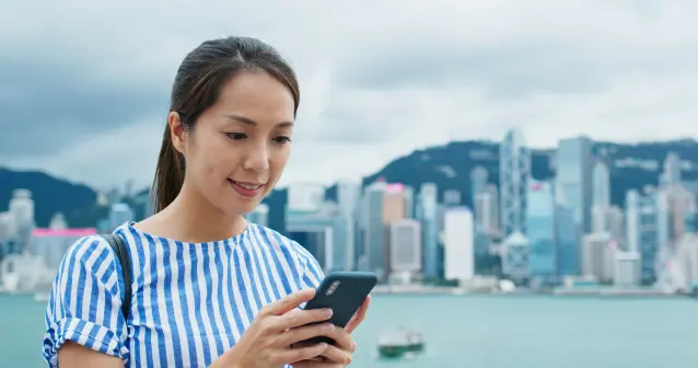 Traveller choosing between a travel eSIM and international mobile roaming